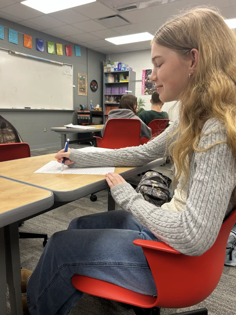 "
Writing on her worksheet, freshman Leah Mulder begins Spanish class by completing her bellwork. Students started every Spanish class with bellwork questions in order to refresh their memory and make sure they’re ready to learn. “Doing bellwork helps me to prepare and get a start to the class,” Mulder said. “It also helps me if I’m questioning something; I can always go over it with the teacher.”"