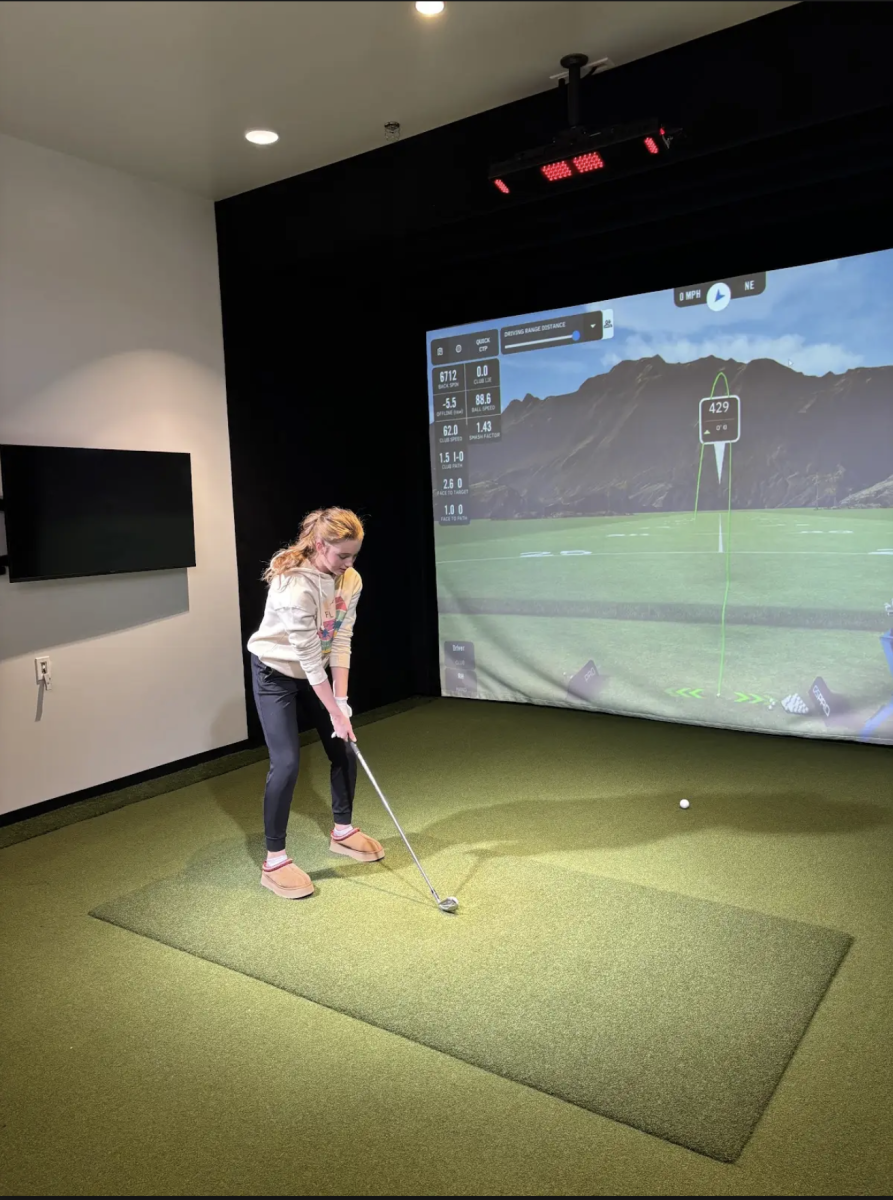 Freshman Addison Kloboves practices in the new girls golf practice facility on Thursday, December 5. This is the first day the golf team was allowed to practice. “I like the hitting facility because it allows me to keep my skills and helps me be ready when our season starts,” Kloboves said. “It helps golf programs grow by showing how much it helps our golfers out.” 
