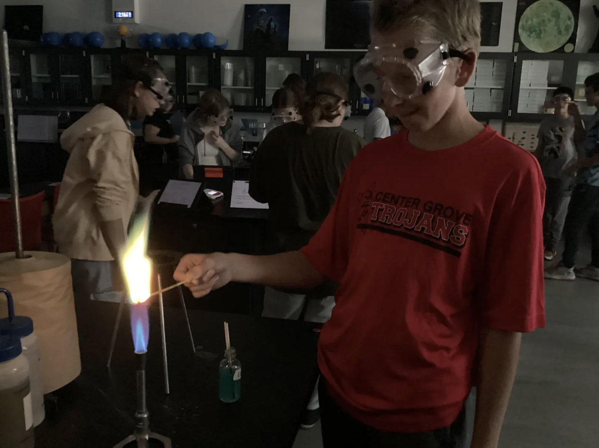 Experimenting with a Bunson Burner, Junior Luke Smith burns a color making matchstick in a lab for chemistry. In Honors Chemistry with teacher Timothy Eddy, students participated in a chemical lab that caused the flame to turn different colors. “This lab is fun because it is different from our typical note taking and allows me to to try new things,” Smith said. 