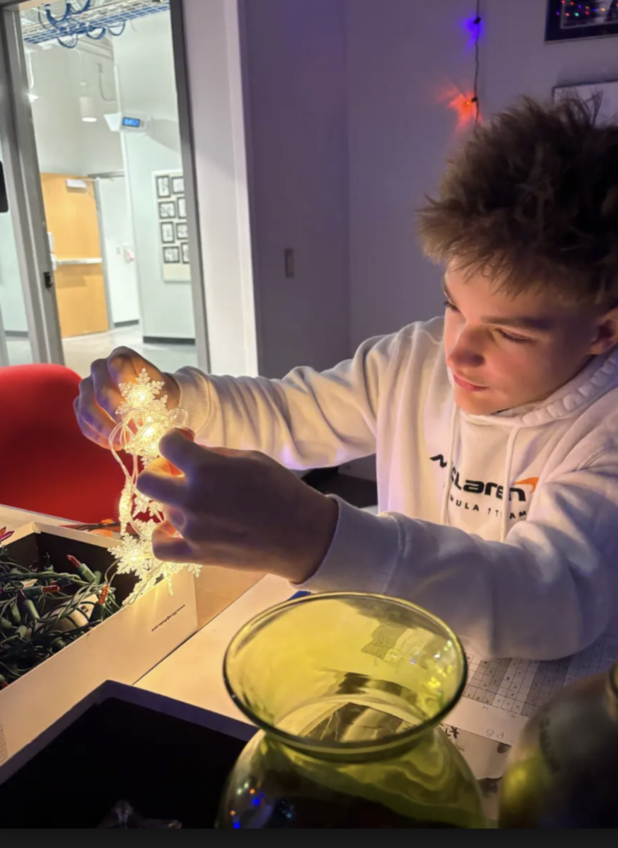 "Senior Brady Newhouse untangles a bundle of Christmas lights in his 6th period Advanced Photography class. In the final period of the semester the students created festive landscapes to enjoy their sendoff to the holiday season. “It was a fun way to end the semester,” Newhouse said. “I enjoyed being able to relax and unwind before finals this week."