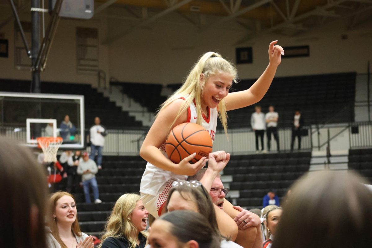 Senior Ella Sprong holds the game ball and celebrates the team’s 29-26 victory over Lawrence Central to clinch a spot in the state championship game. The Trojans will take on Norwell for the state title at 8:15 p.m. Saturday at Gainbridge Fieldhouse.