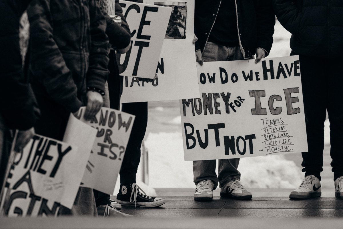 Students gather outside the Hall of Excellence with homemade signs during Friday's anti-ICE protest.