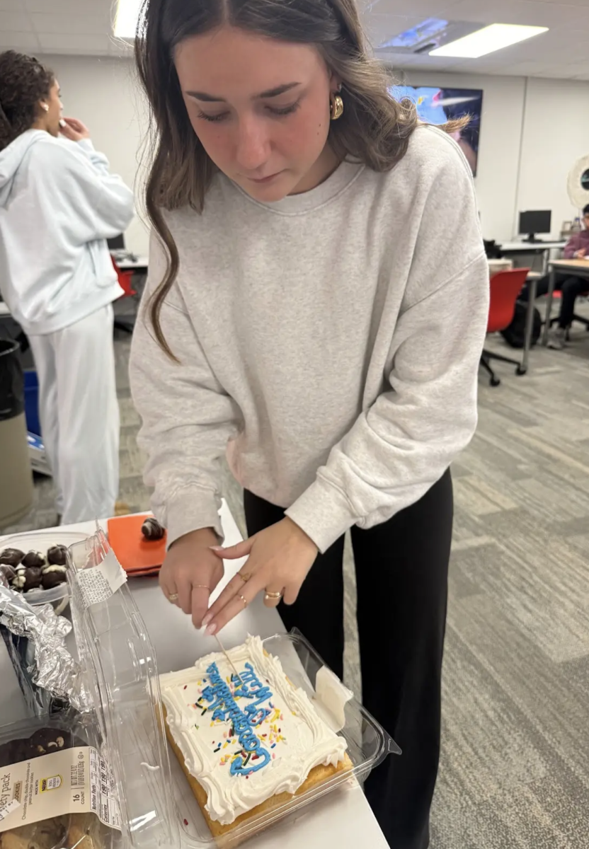 Senior Gabby Unger slices a cake made for a STAR Party. Students in Mrs. Tzaferis’ STAR decided to throw Will Vander Luitgaren a party to celebrate him coming in 4th at the IHSAA Wrestling State Tournament. “Throughout the year Will wasn’t able to eat some of the food that was at our STAR Parties because he was cutting weight,” Unger said. “I wanted to celebrate will by planning a party to let him eat all of the desert and pizza that he missed out on.”