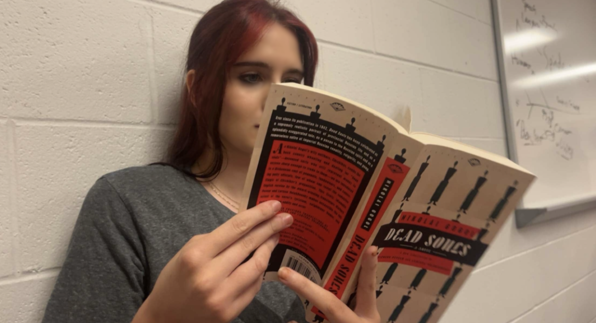 Flipping through pages, Michaela reads about Pavel, a man who travels Russia to buy the names of dead peasants still listed as alive on government records
