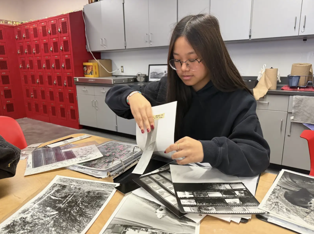 In Mrs. Fowler's first period class, sophomore Engedi Chin gets ready for her finals by organizing all of her pictures from this year. Chin just finished printing her last pictures of the year and is getting her binder ready for her final which is a portfolio of all of her pictures. “This last roll we were allowed to do whatever we wanted to,” Chin said. “I love seeing all of my pictures in one place to see all of my work and what I did over this year.”